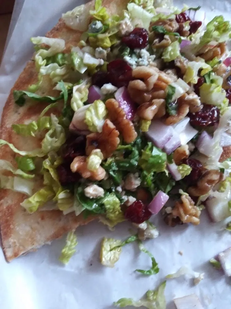 Argula Topped w Walnuts Cranberries with a Glaze on a Brick Oven Pizza Base